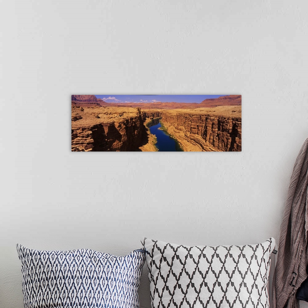 A bohemian room featuring A panoramic photograph of an ancient waterway passing through the rock cliffs it has eroded over ...