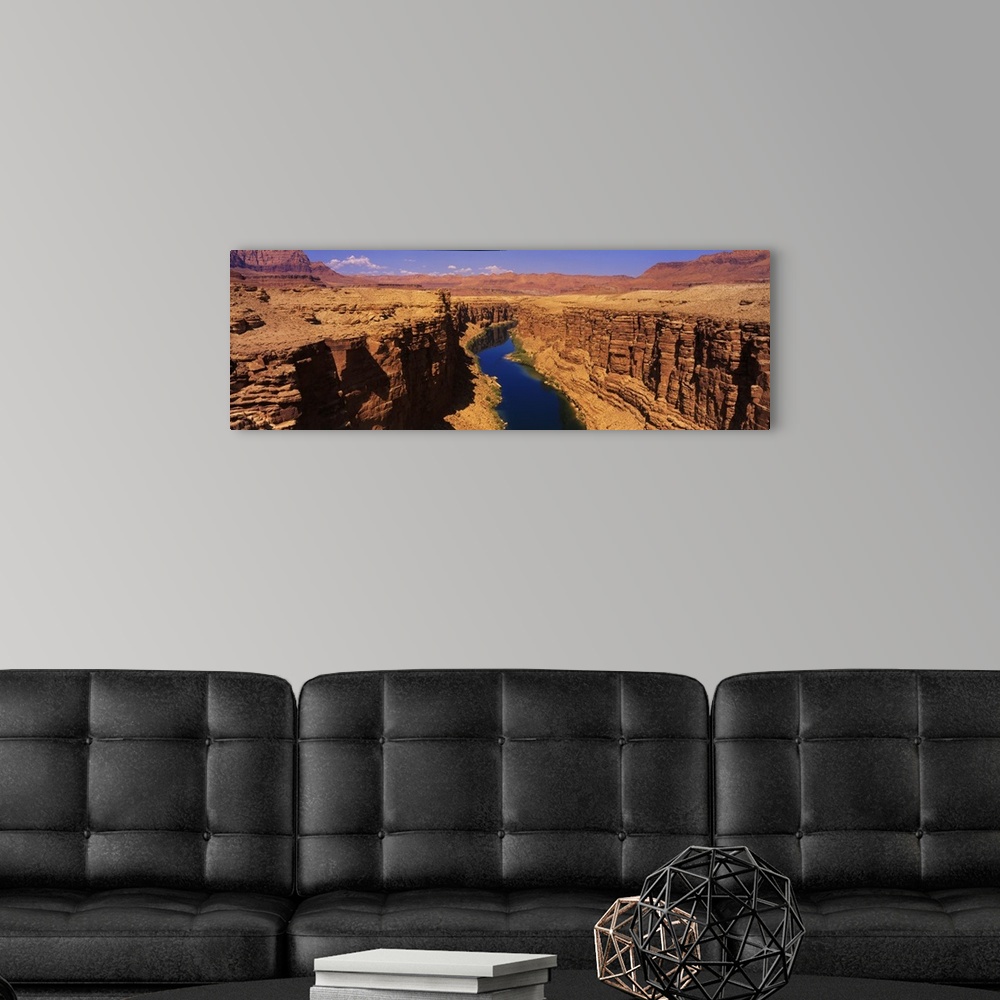A modern room featuring A panoramic photograph of an ancient waterway passing through the rock cliffs it has eroded over ...