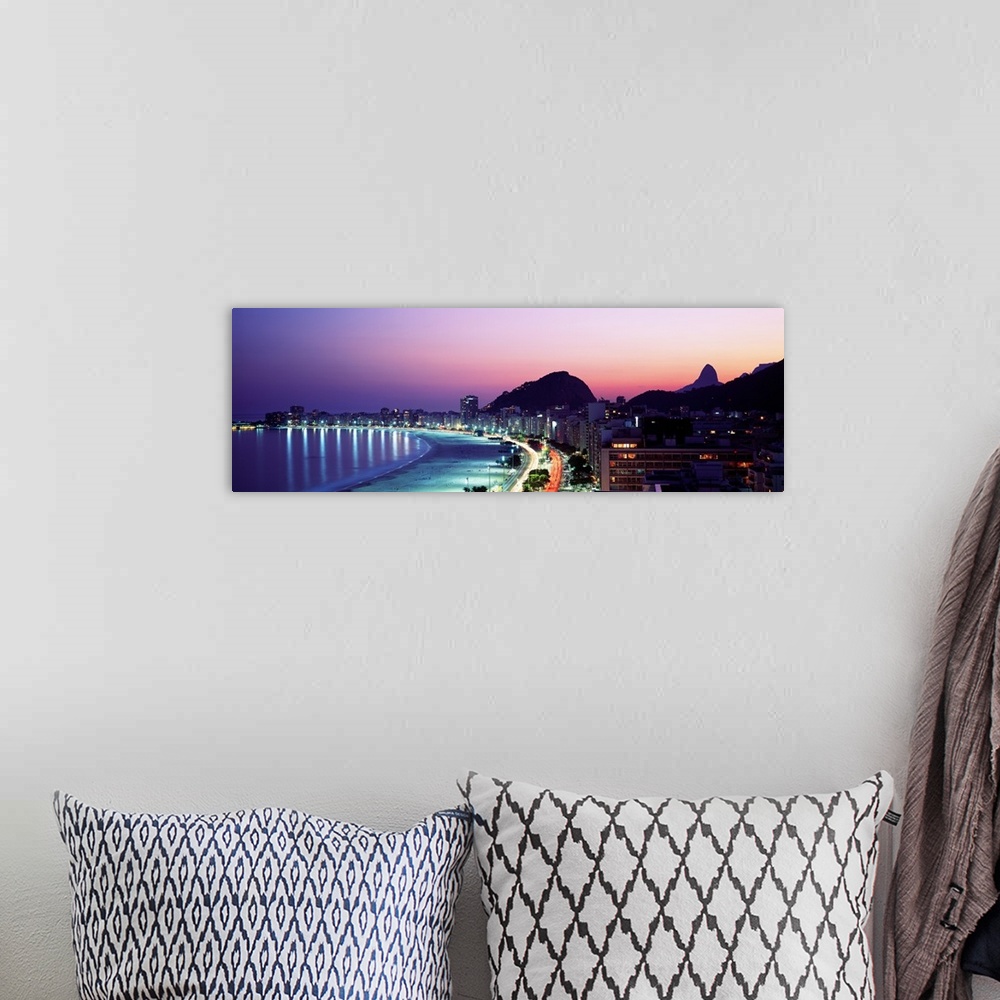 A bohemian room featuring Panoramic, giant photograph of buildings lit along Copacabana Beach at night, mountains in the ba...