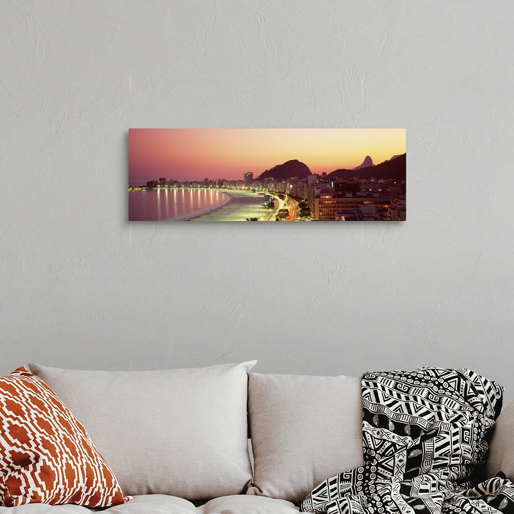 A bohemian room featuring Giant landscape photograph of the curving shoreline of Copacabana Beach, lined with buildings tha...