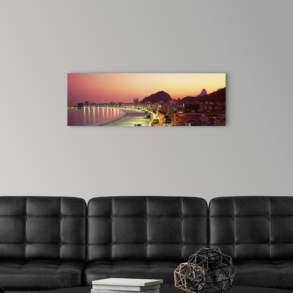 A modern room featuring Giant landscape photograph of the curving shoreline of Copacabana Beach, lined with buildings tha...