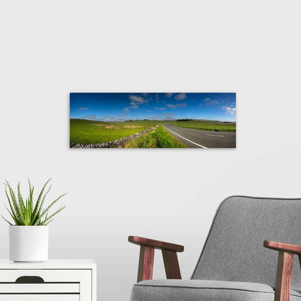 A modern room featuring Country road passing through a landscape, Tynedale, Northumberland, England