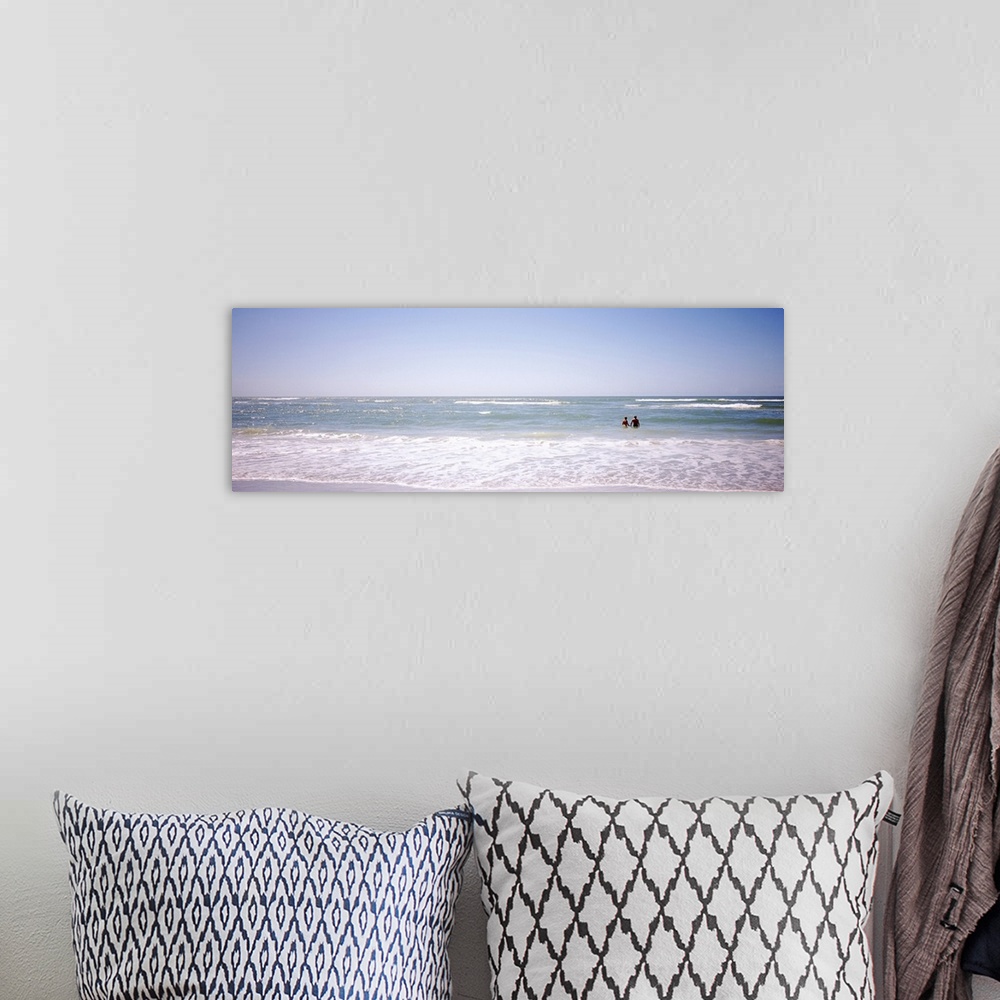 A bohemian room featuring Panoramic image on canvas of the ocean with two people standing in it.
