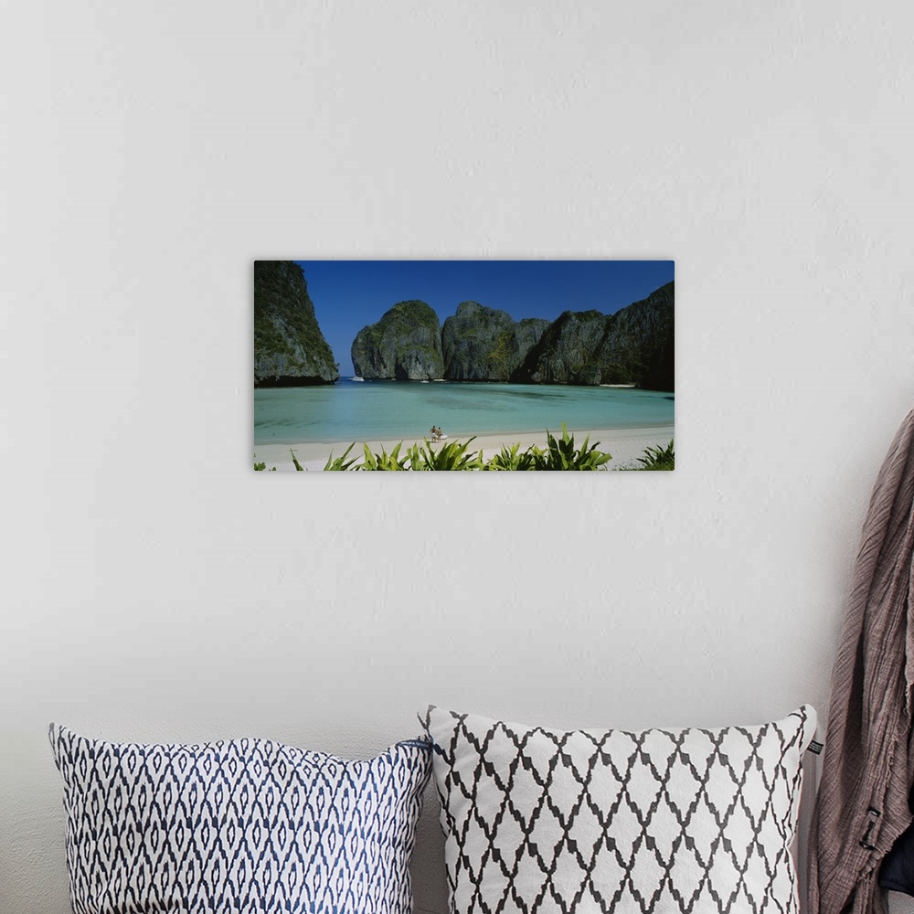 A bohemian room featuring A breathtaking photograph of a beach in Thailand surrounded by mountains with a couple at the edg...