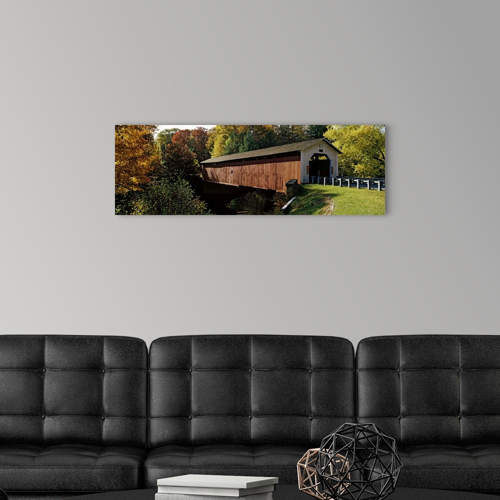 A modern room featuring Panoramic photograph of the wooden McGees Mill covered bridge, surrounded by a forest of trees wi...