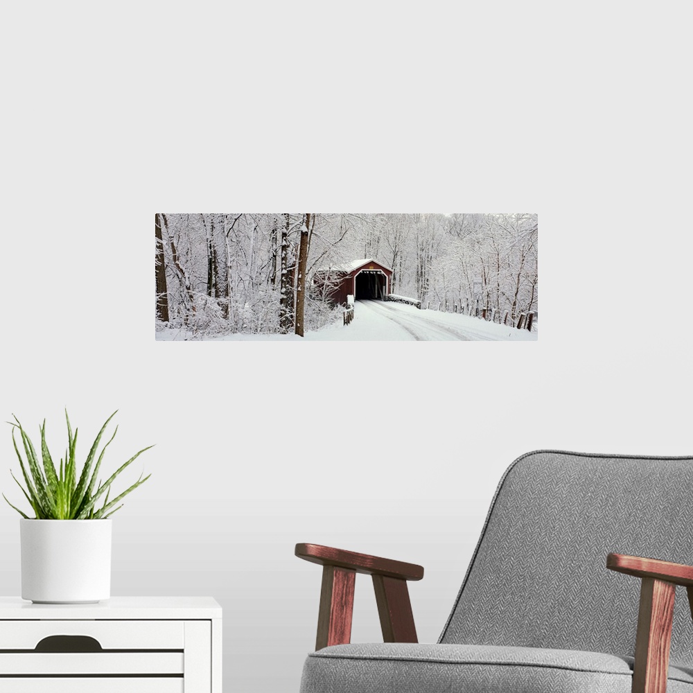 A modern room featuring Panoramic photograph of a snow covered bridge in Pennsylvania that is surrounded by a forest.