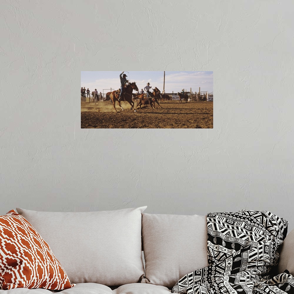 A bohemian room featuring Panoramic photo on canvas of men riding horses trying to rope a baby cow.