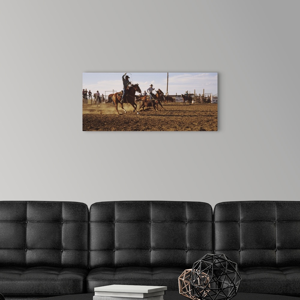A modern room featuring Panoramic photo on canvas of men riding horses trying to rope a baby cow.