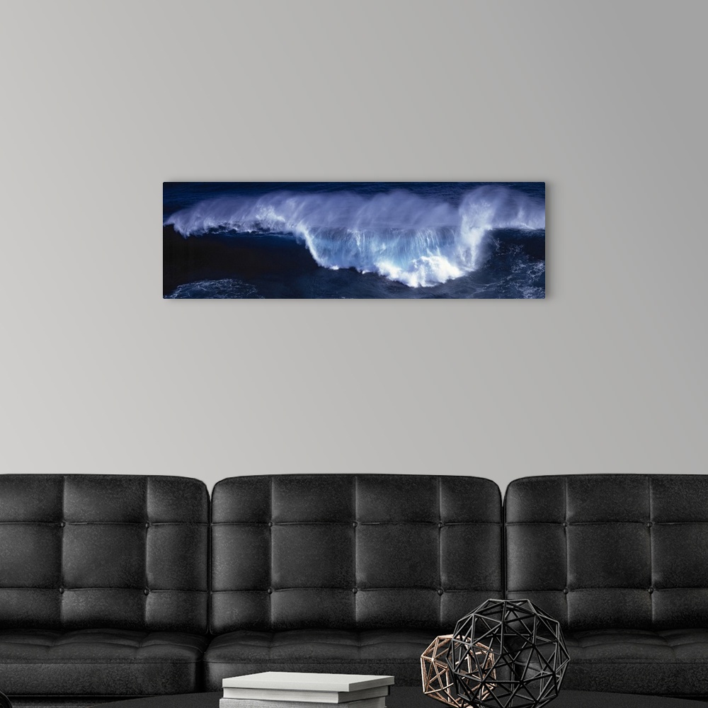 A modern room featuring Wide angle shot of a huge wave that has begun to crash down.