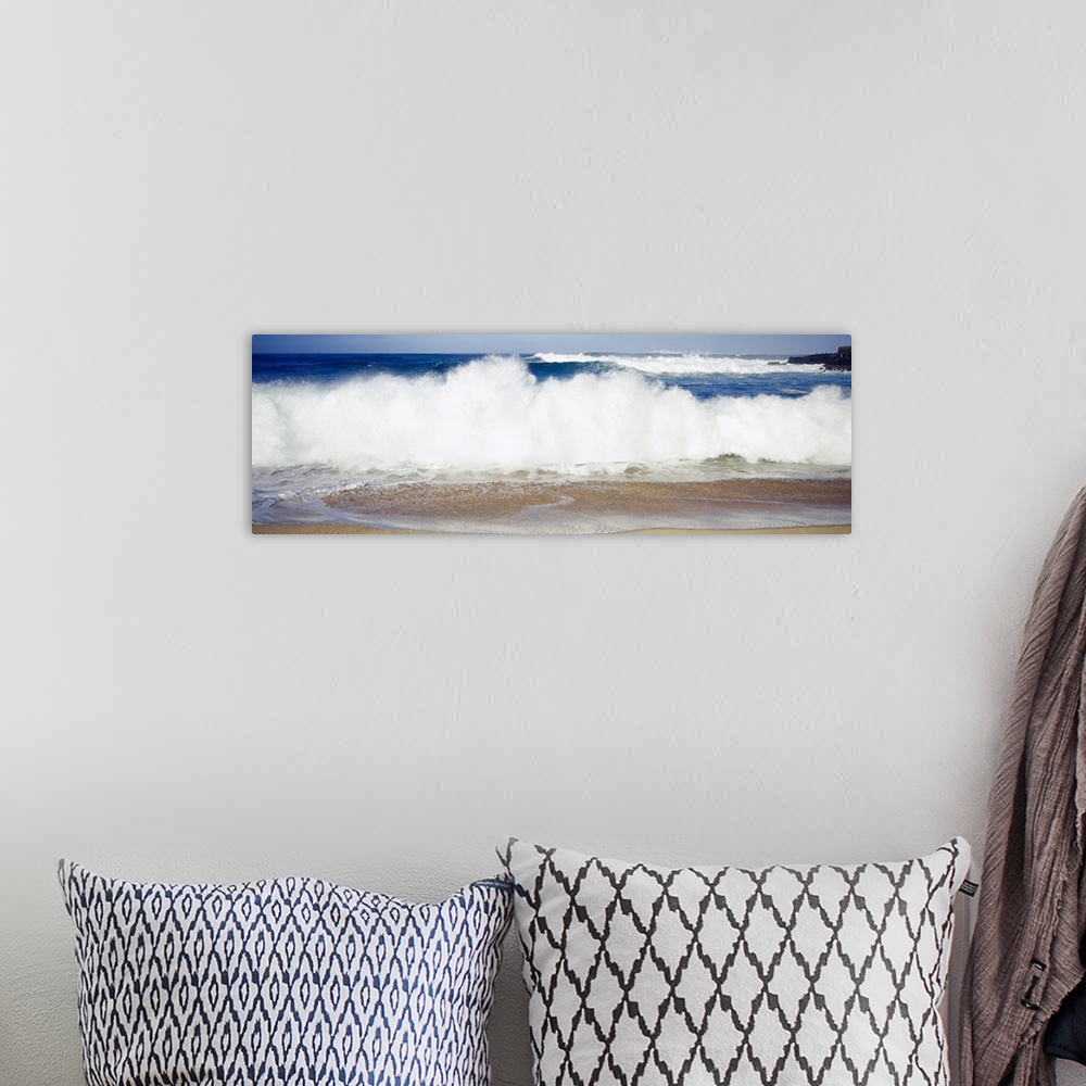 A bohemian room featuring Panoramic photograph of large waves crashing into the beach, bright blue water in the background,...