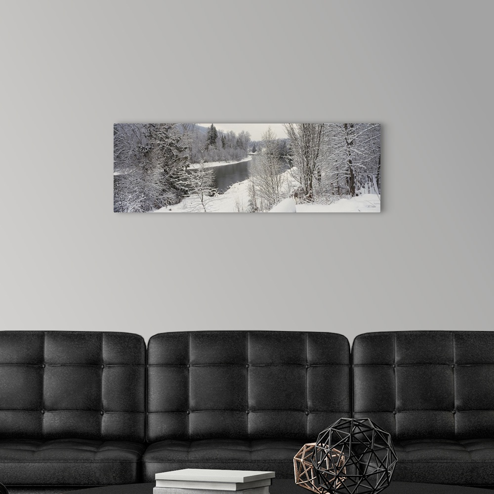 A modern room featuring River and surrounding trees blanketed in snow from a recent snowfall, giving the landscape a quie...