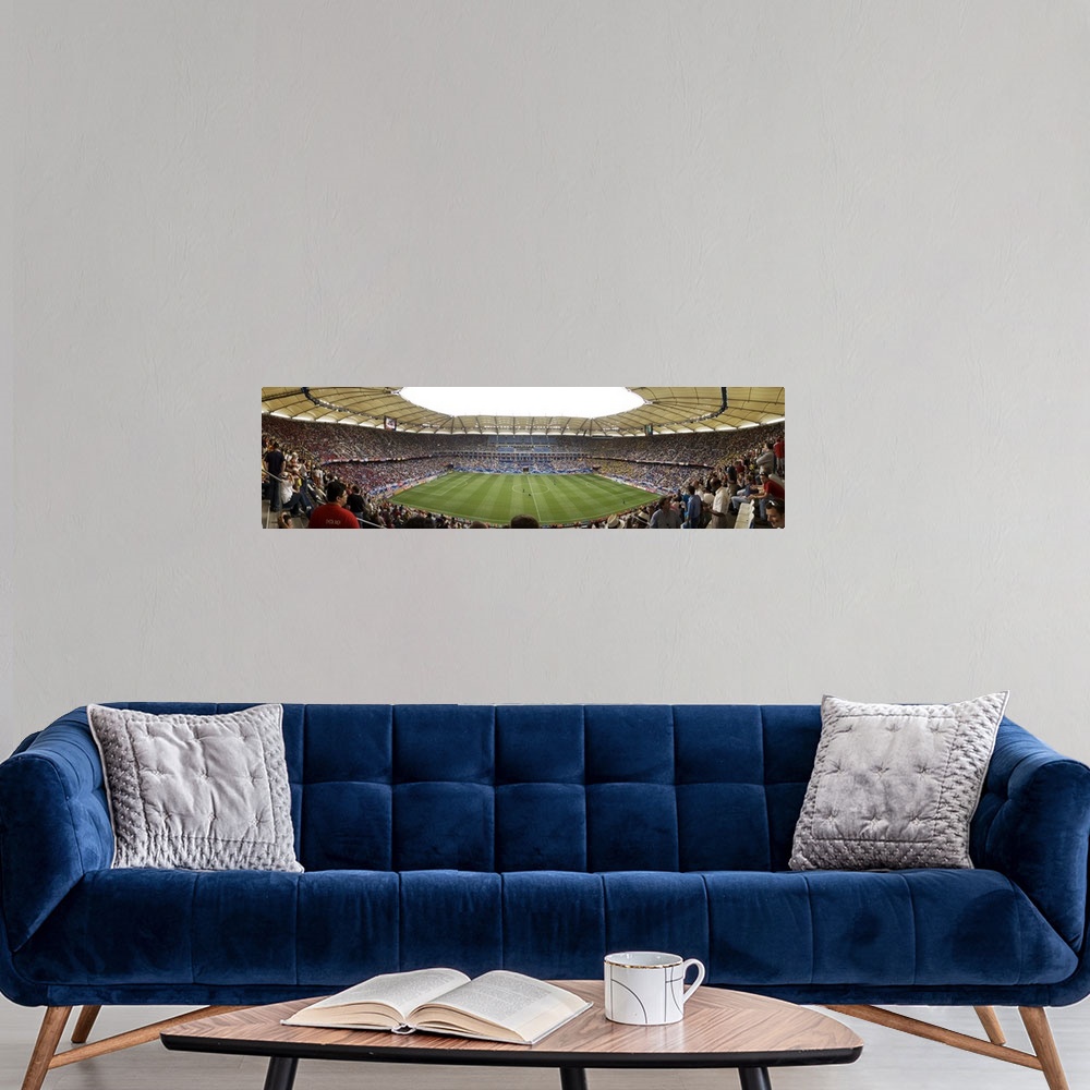 A modern room featuring Wide angle photograph of large stadium full of fans, watching a soccer game in Hamburg, Germany.