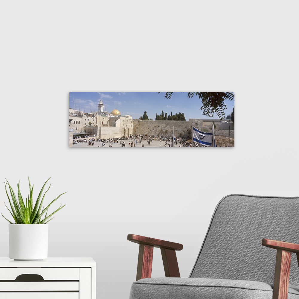 A modern room featuring Wide angle photograph of a crowd of people surrounding the Wailing Wall in Jerusalem, Israel, the...