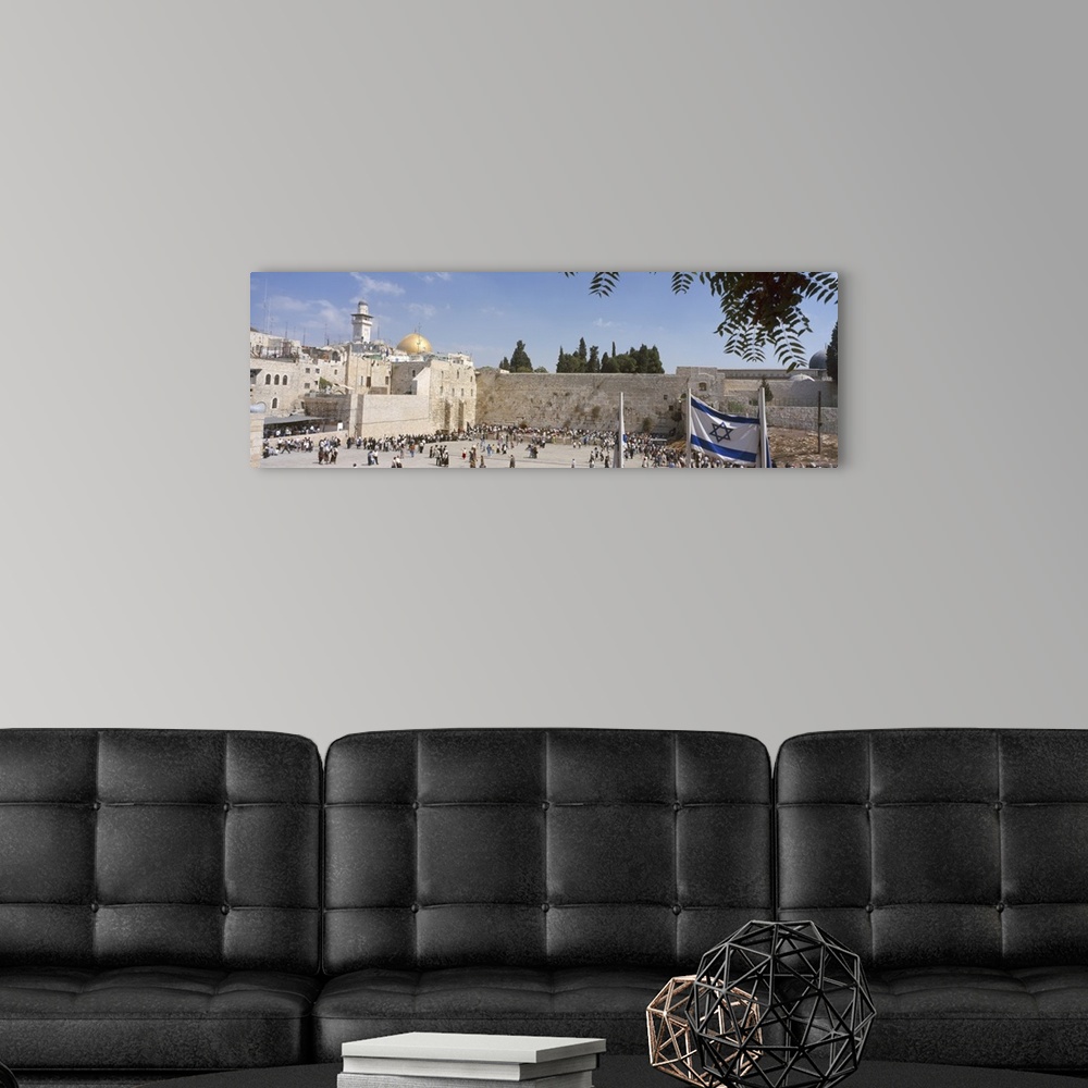 A modern room featuring Wide angle photograph of a crowd of people surrounding the Wailing Wall in Jerusalem, Israel, the...