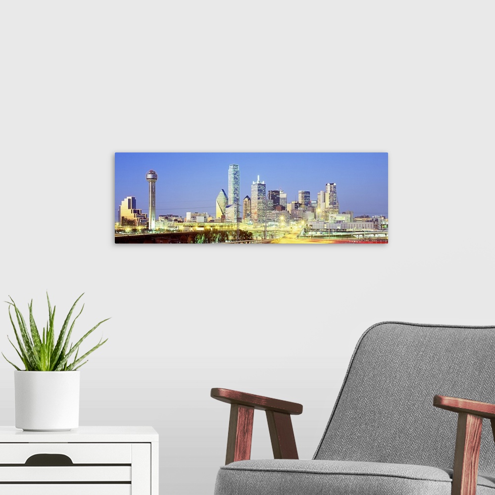A modern room featuring Giant, landscape photograph of a highway road leading toward the lit up Dallas skyline against a ...