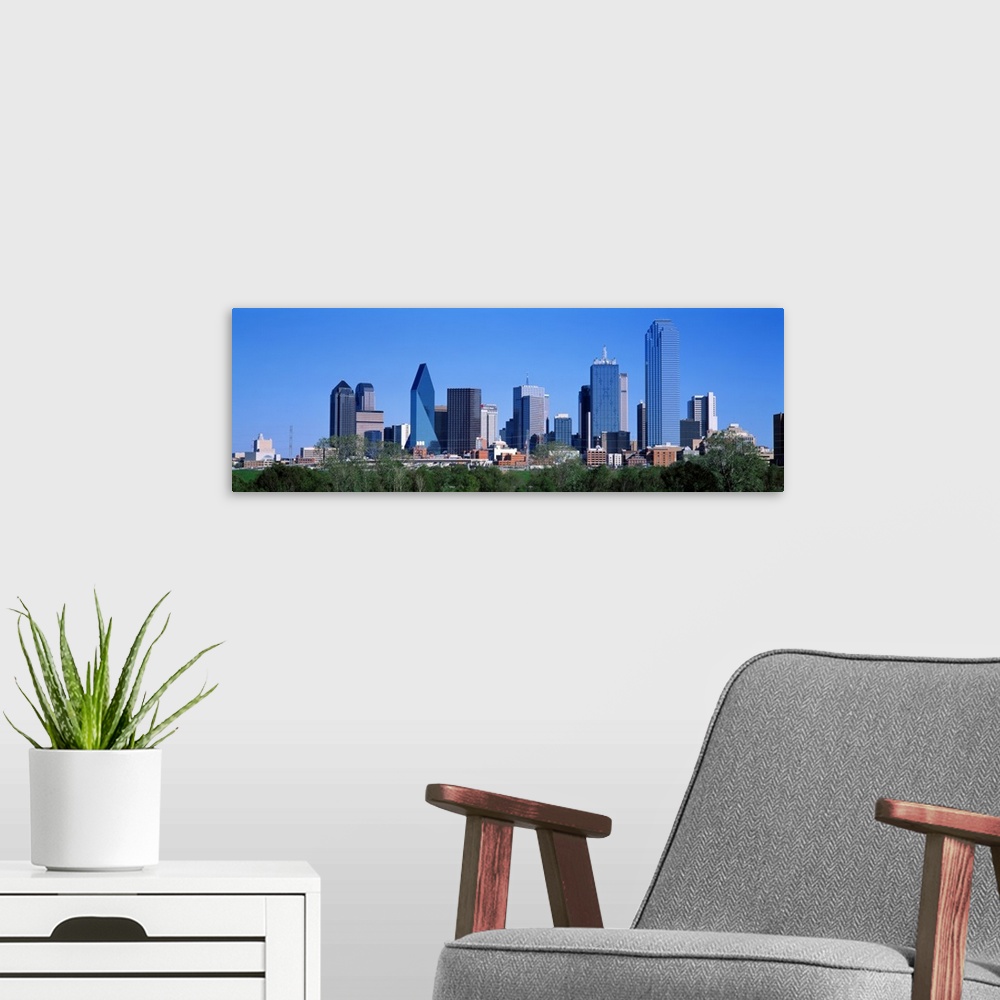 A modern room featuring The city skyscrapers reflect the colors of the sky in this panoramic photograph taken on a sunny ...
