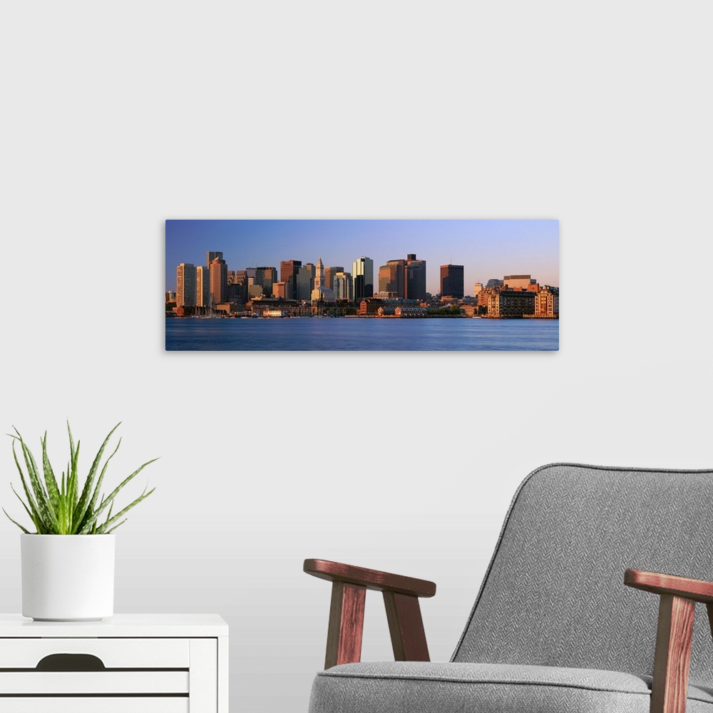 A modern room featuring Large panoramic photograph of the Boston skyline from across the river with the sun hitting the b...