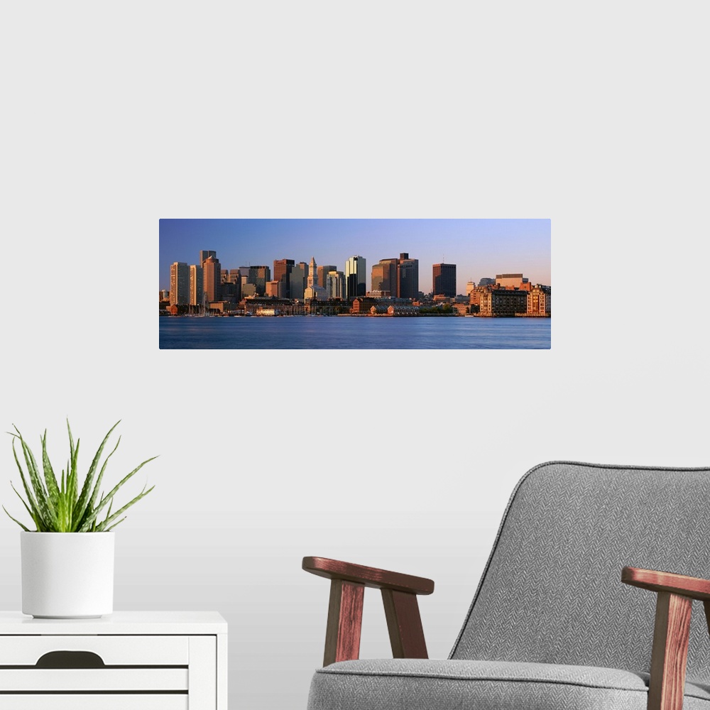 A modern room featuring Large panoramic photograph of the Boston skyline from across the river with the sun hitting the b...
