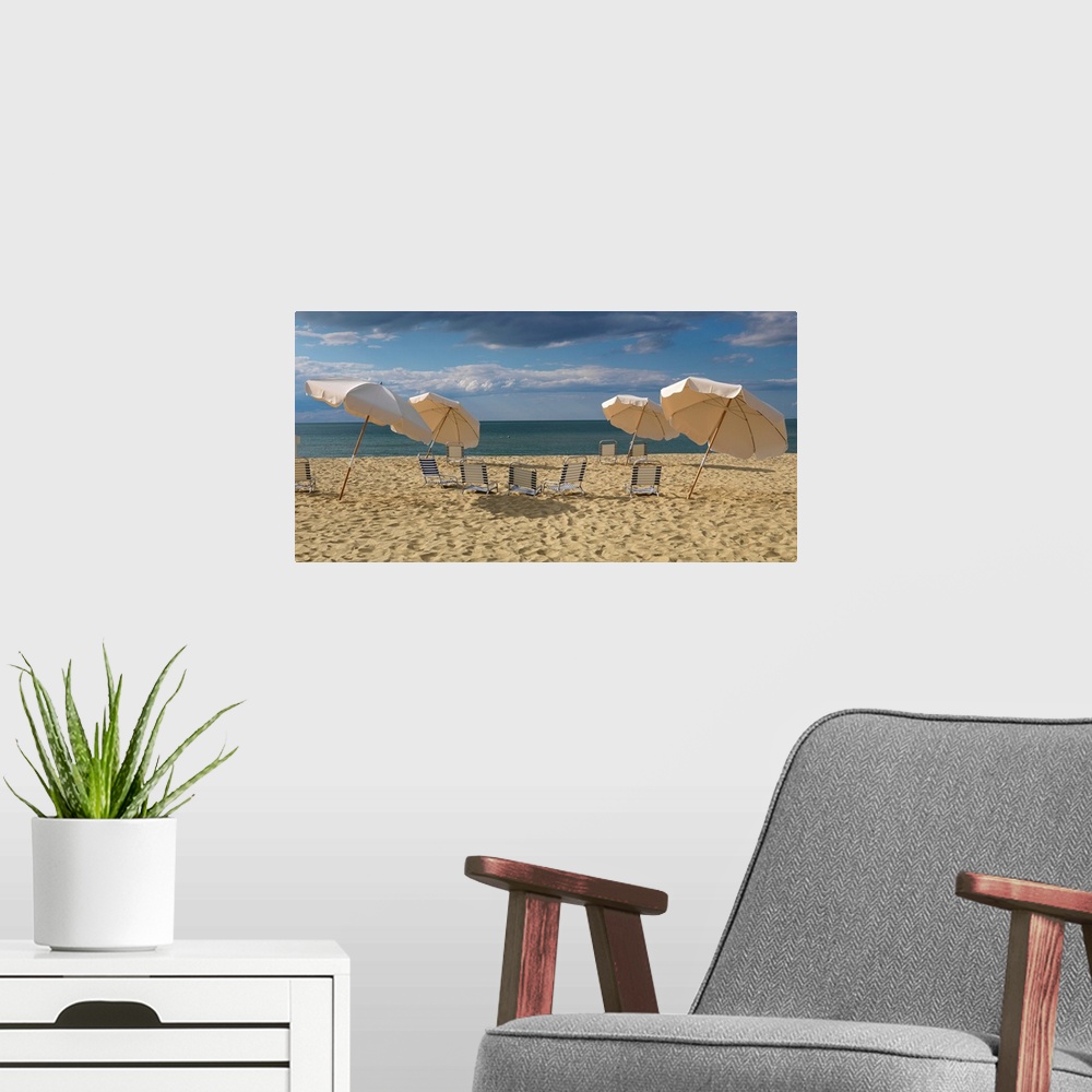 A modern room featuring Landscape photograph of a heavily traveled beach on the New England coast with clouds gathering i...