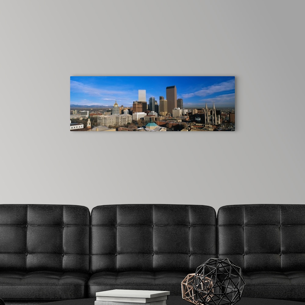 A modern room featuring Panoramic photo of a downtown cityscape in Colorado against a bright blue sky.