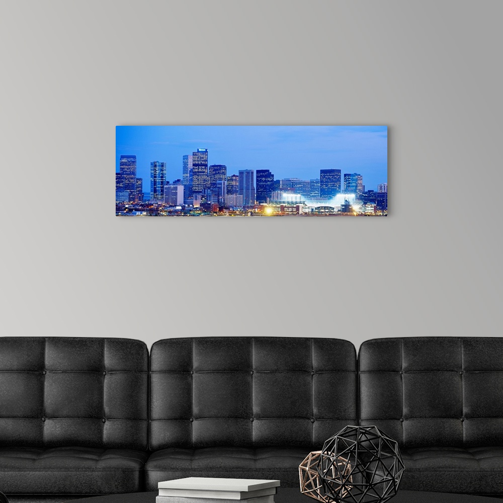 A modern room featuring A panoramic skyline photograph showing city lit up at night.