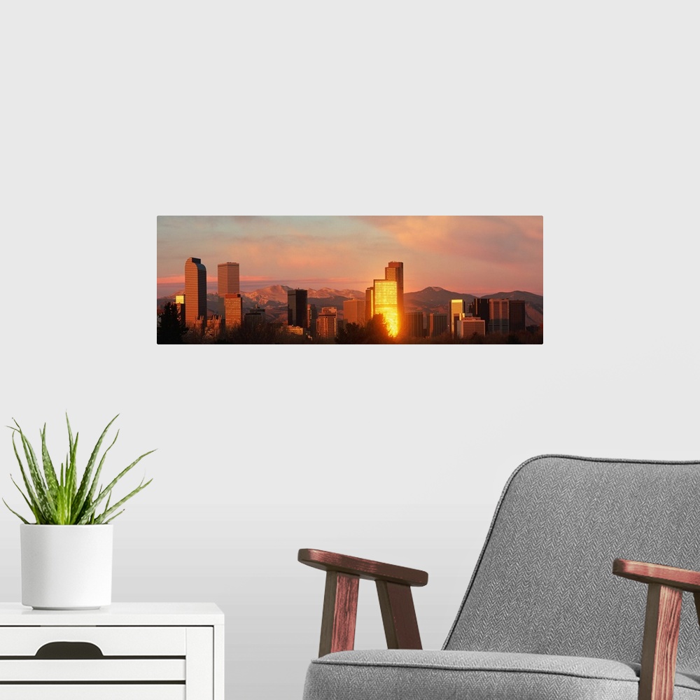 A modern room featuring A panoramic shot taken of the Denver skyline while the sun is setting and reflecting off some of ...
