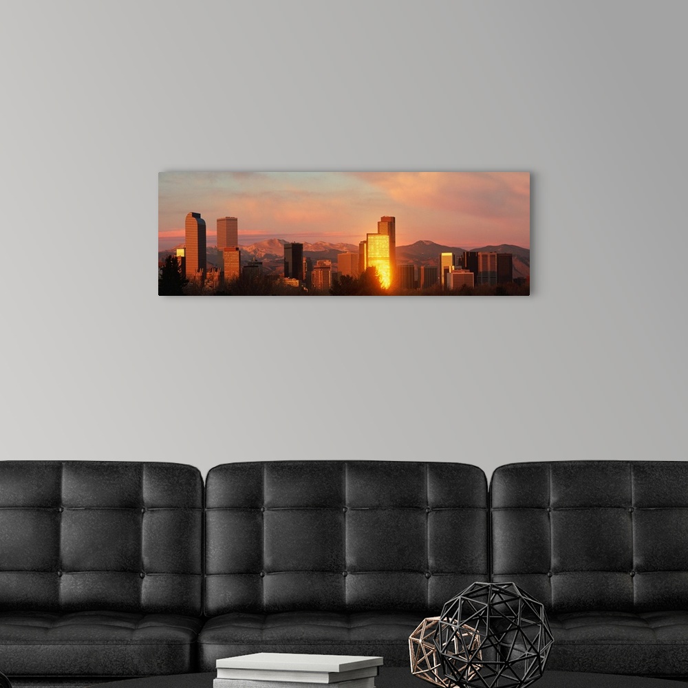 A modern room featuring A panoramic shot taken of the Denver skyline while the sun is setting and reflecting off some of ...