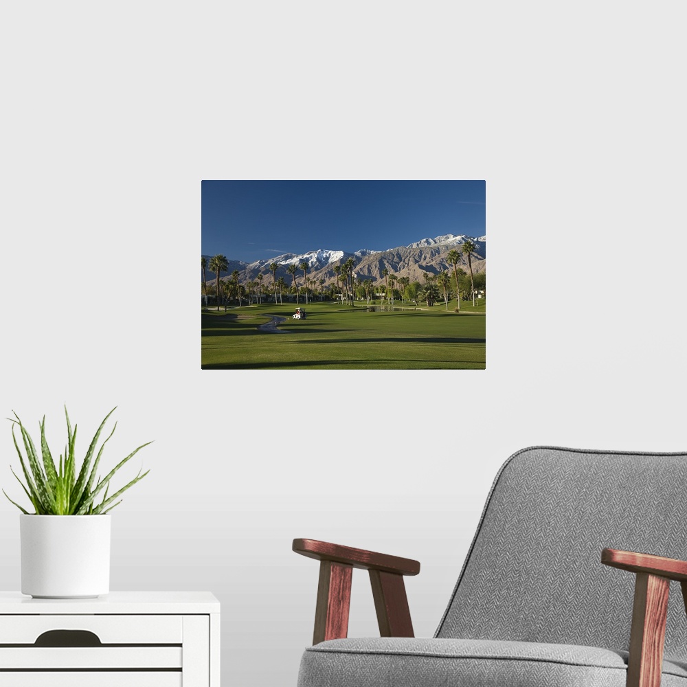 A modern room featuring Oversized, horizontal photograph of a golf cart on the green of golf course at the Desert Princes...