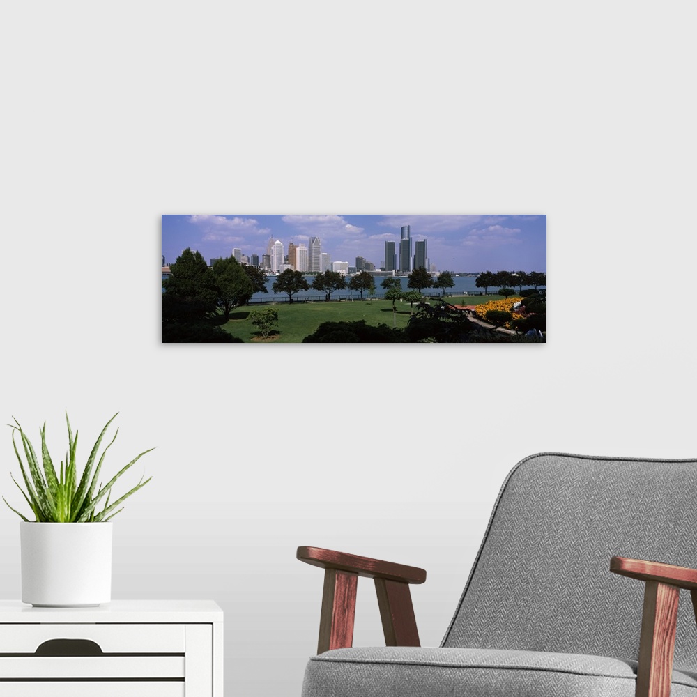 A modern room featuring This wall art is a panoramic photograph of the city skyline taken from a park across the water.