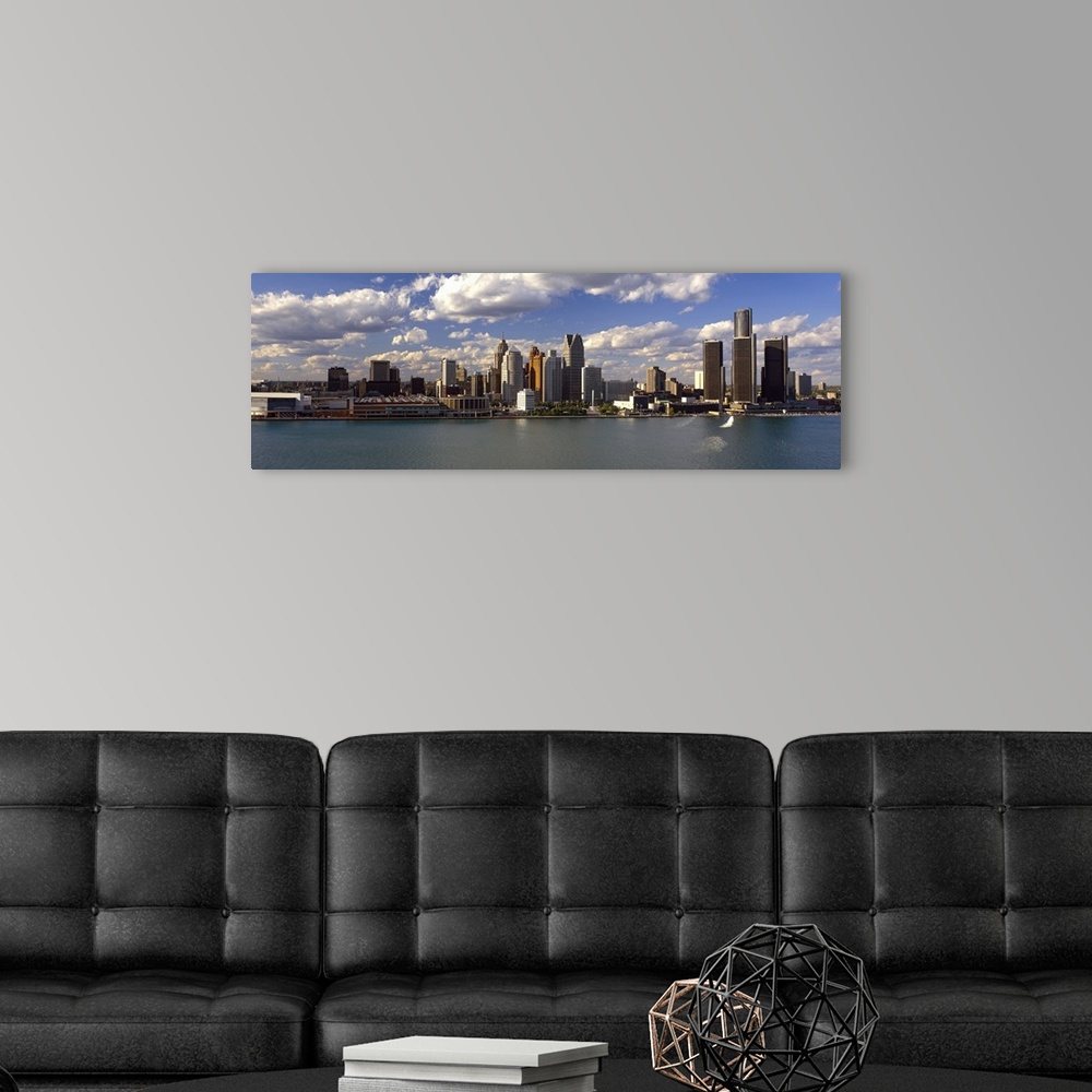 A modern room featuring This panoramic photograph shows the city skyline at midday taken from on the water.