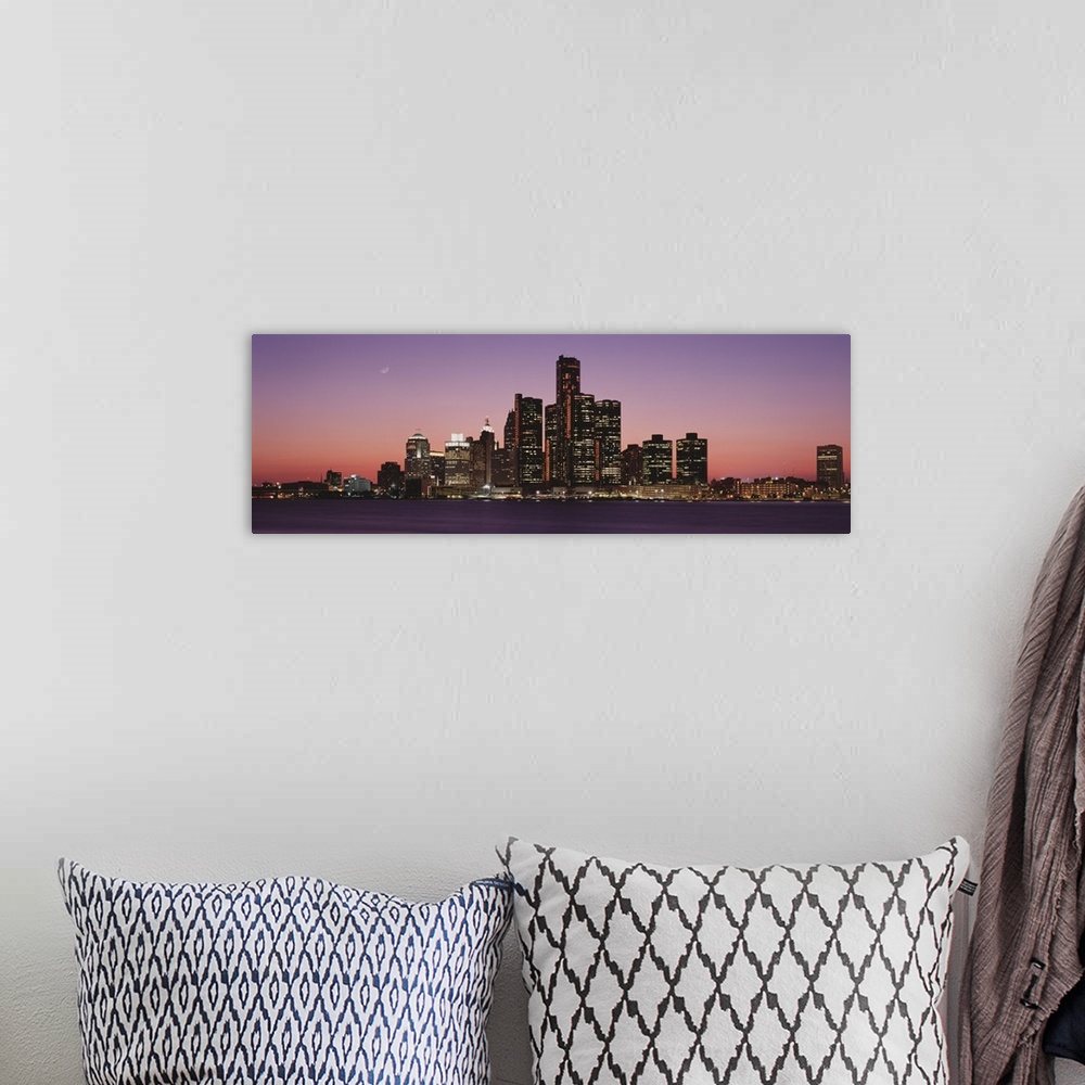 A bohemian room featuring Panoramic photograph of skyline and waterfront lit up at sunset with the moon high in the sky.