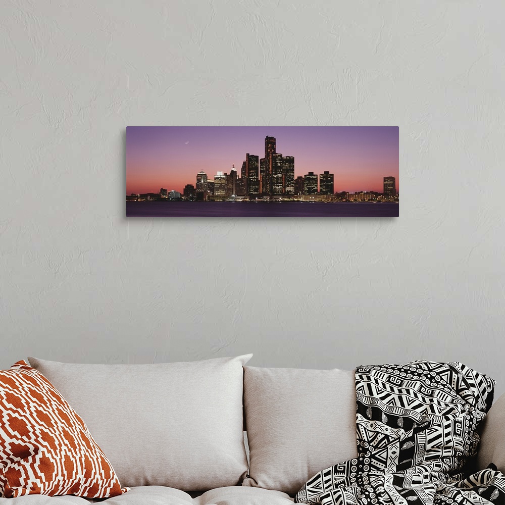 A bohemian room featuring Panoramic photograph of skyline and waterfront lit up at sunset with the moon high in the sky.
