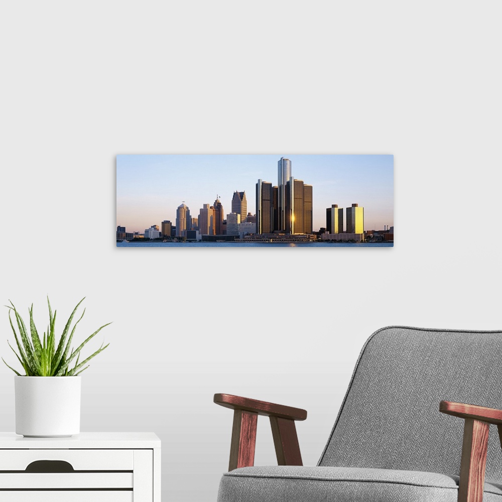 A modern room featuring Panoramic photograph of city skyline with waterfront.  The sun is reflecting off one of the skysc...
