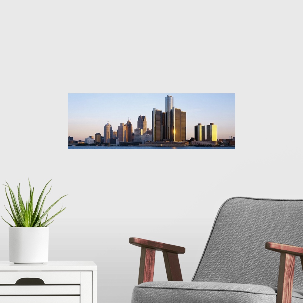 A modern room featuring Panoramic photograph of city skyline with waterfront.  The sun is reflecting off one of the skysc...