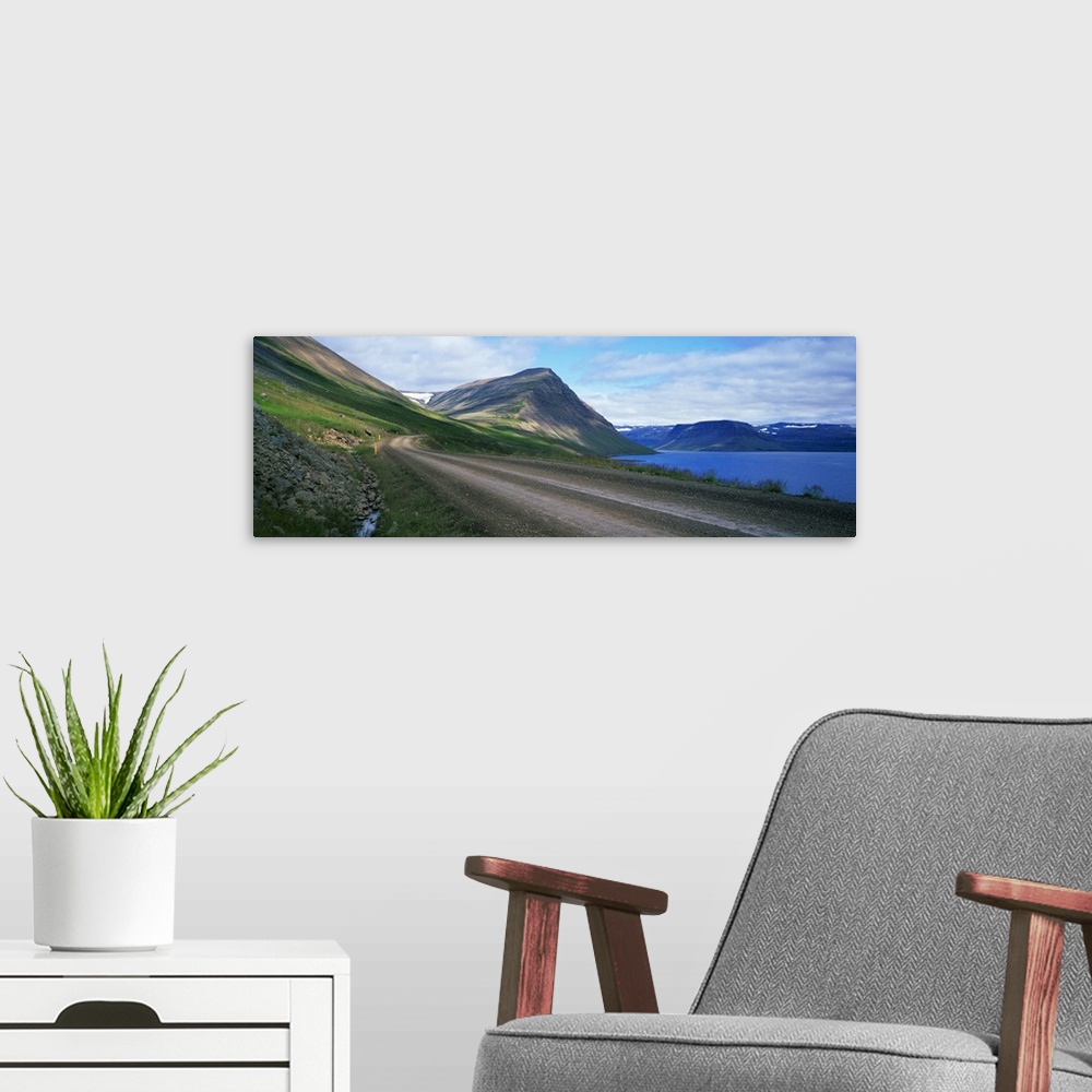 A modern room featuring Dirt road along mountain lake, Iceland