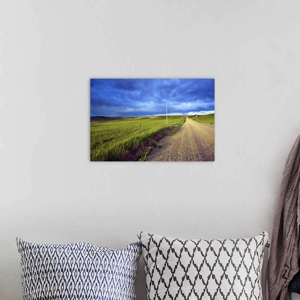 A bohemian room featuring Landscape, oversized photograph of a gravel road, open fields on wither side, beneath a stormy sk...