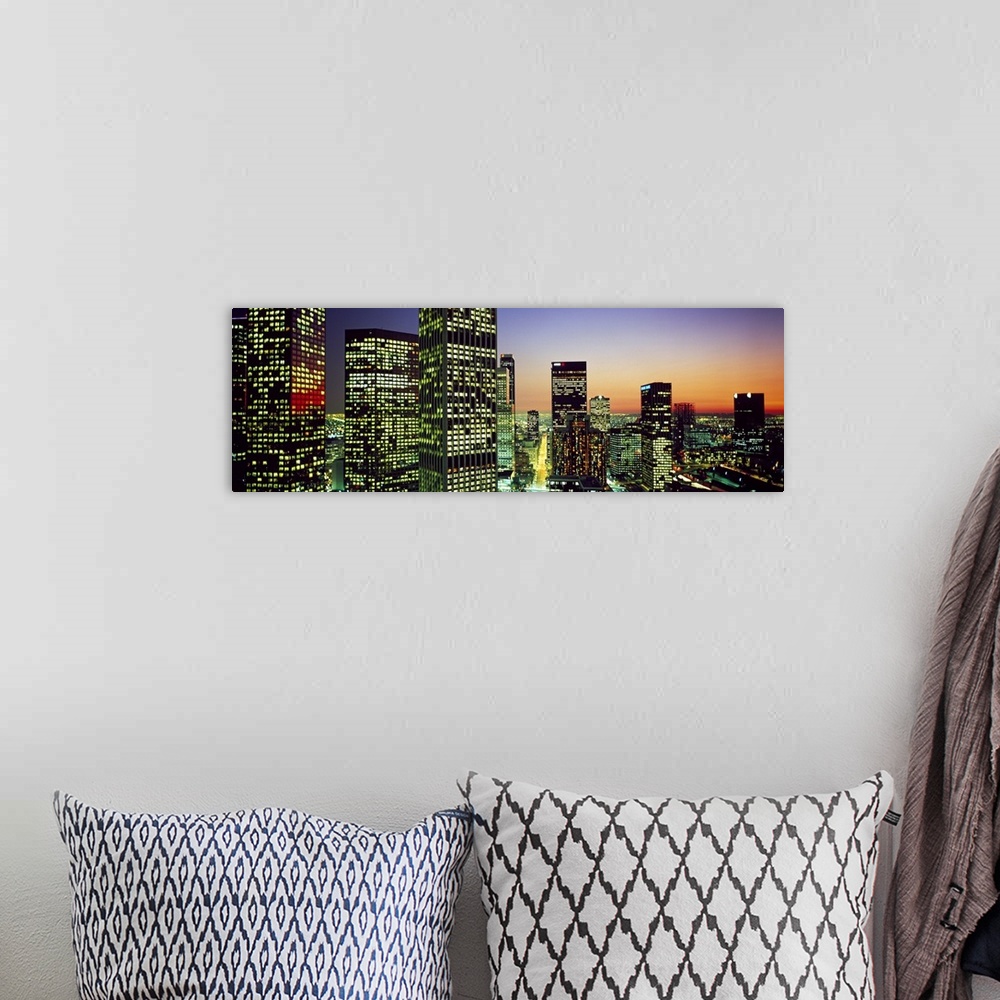 A bohemian room featuring Panoramic photo of an illuminated cityscape up close to the buildings at sunset.
