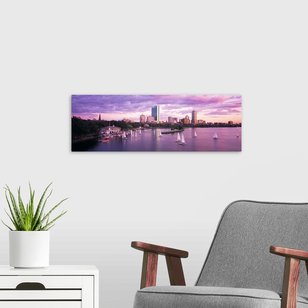 A modern room featuring Panoramic photograph of skyline and waterfront at sunset.  There are sailboats in the water under...