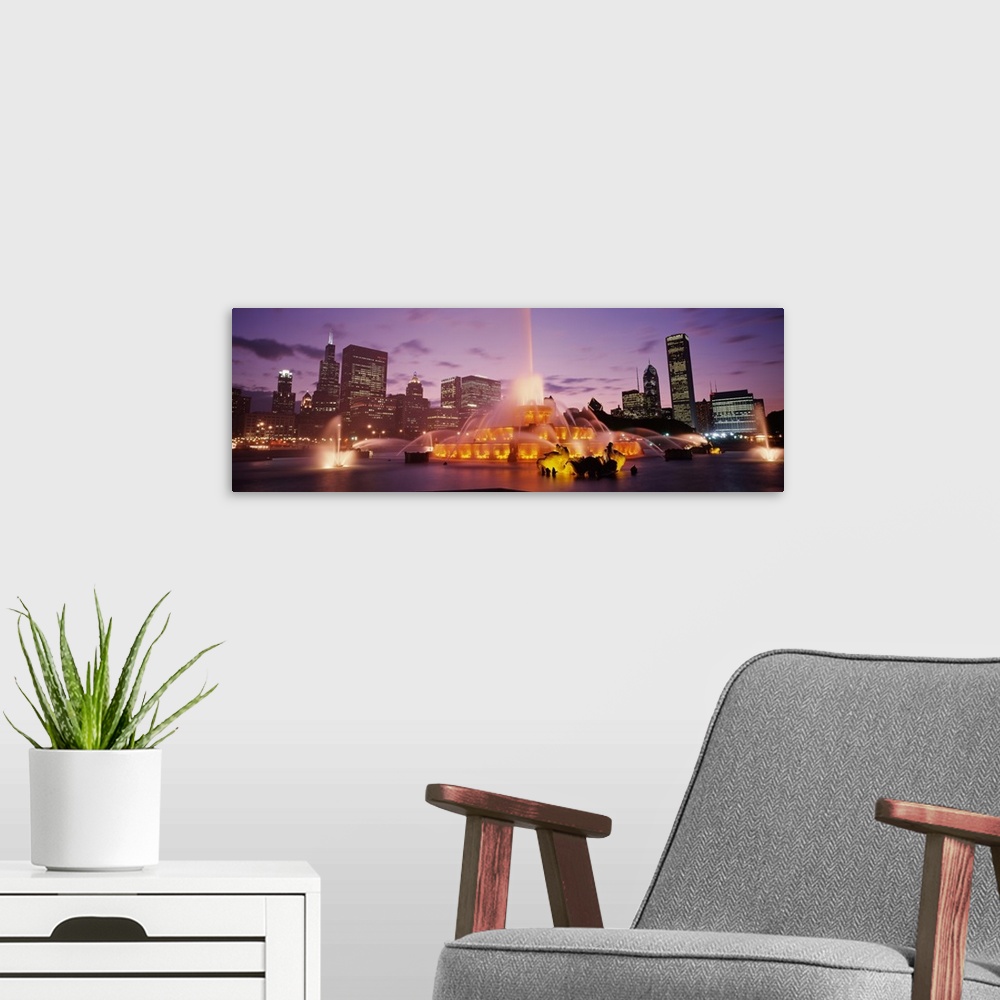 A modern room featuring Panoramic photograph taken of Buckingham Fountain lit up at dusk as it sprays water in an intrica...
