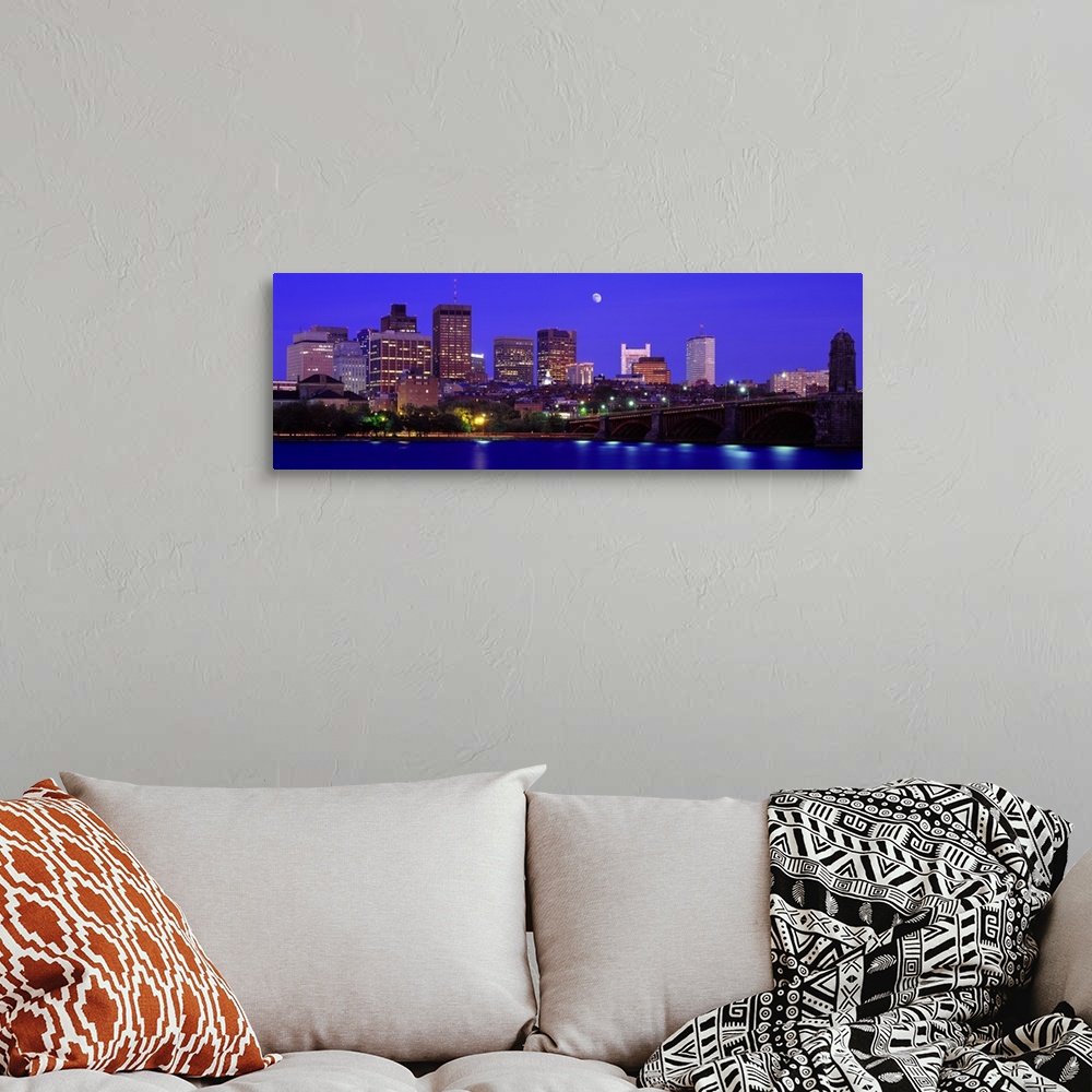 A bohemian room featuring Panoramic canvas of a cityscape on the waterfront with a bridge leading to it and a bright moon i...