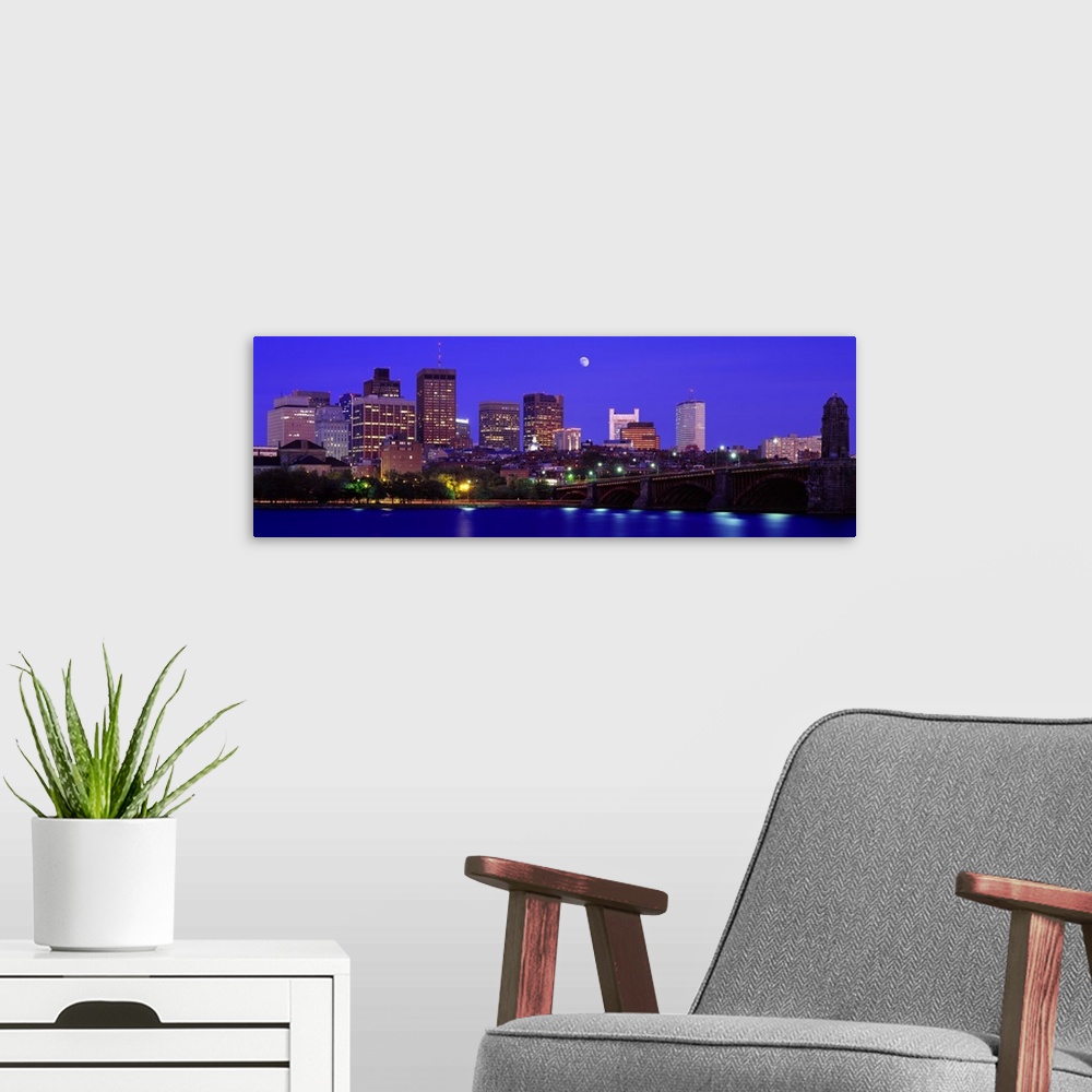 A modern room featuring Panoramic canvas of a cityscape on the waterfront with a bridge leading to it and a bright moon i...