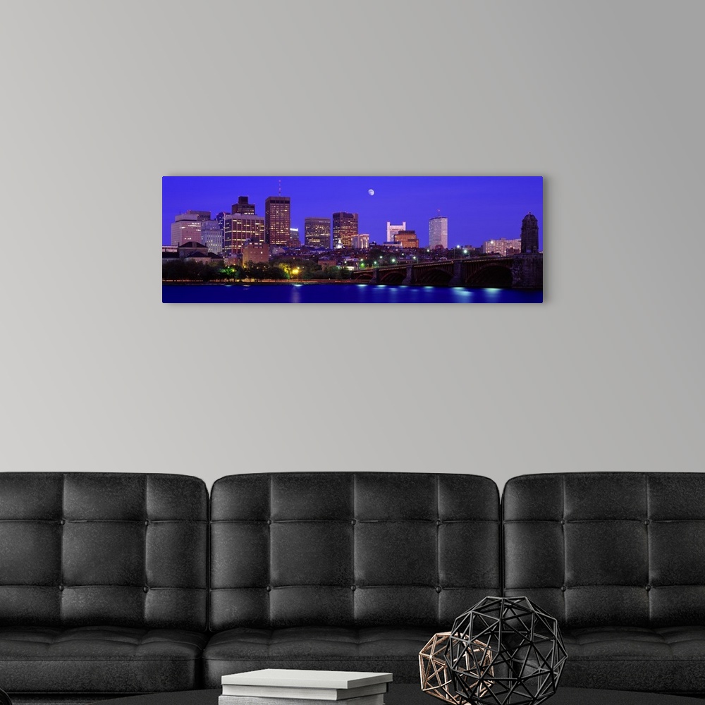 A modern room featuring Panoramic canvas of a cityscape on the waterfront with a bridge leading to it and a bright moon i...
