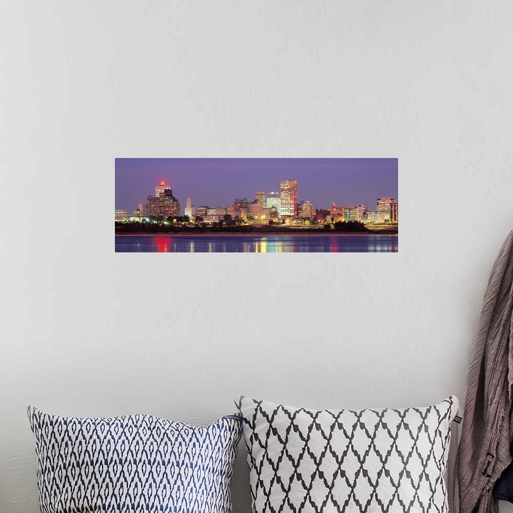 A bohemian room featuring Panoramic photograph of skyline with buildings lit up and reflecting off the waterfront at night.