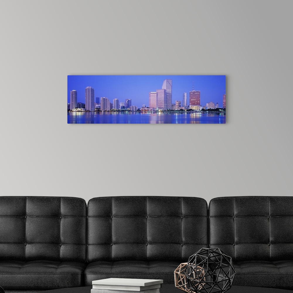 A modern room featuring Landscape giant photograph of downtown Miami at night, with skyscraper and city light reflections...