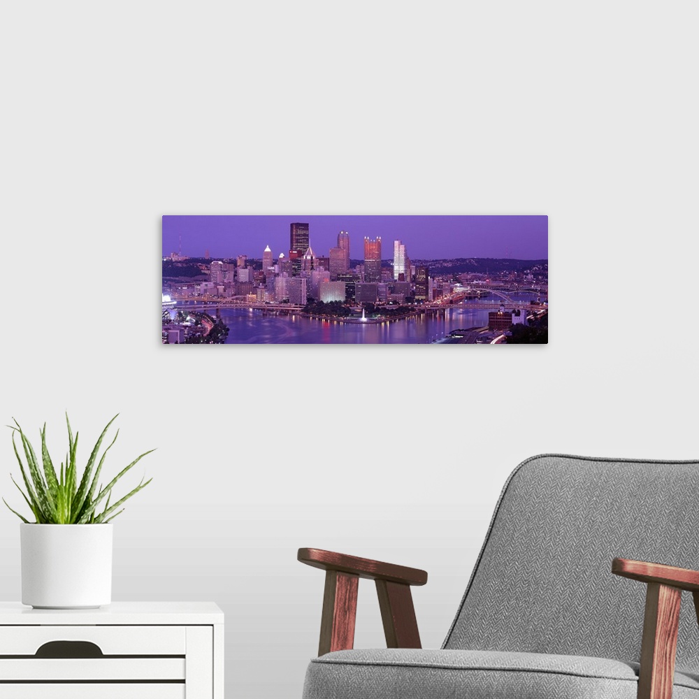 A modern room featuring Big, wide angle photograph of Pittsburgh taken at night.