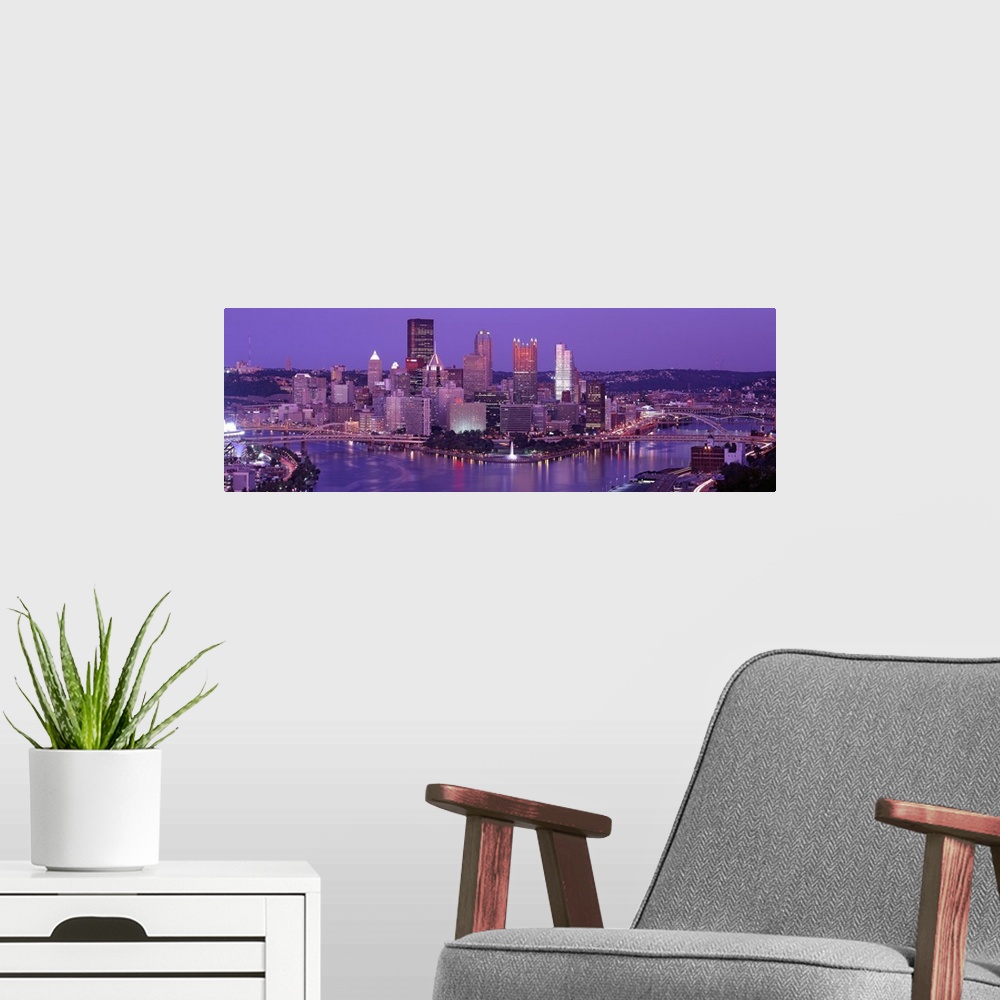 A modern room featuring Big, wide angle photograph of Pittsburgh taken at night.