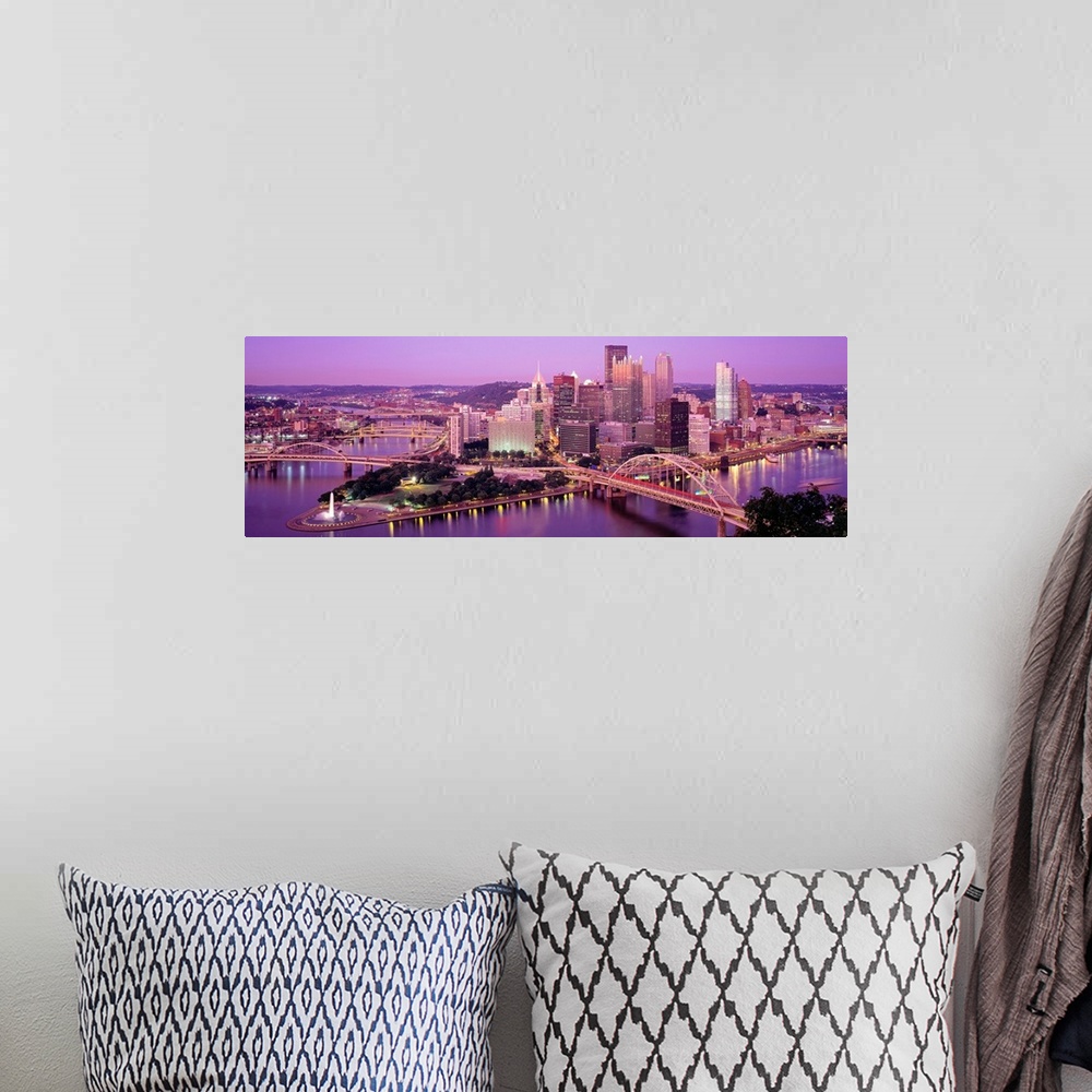 A bohemian room featuring Panoramic photograph of downtown Pennsylvania as the sun sets.  There are building, bridges, a fo...