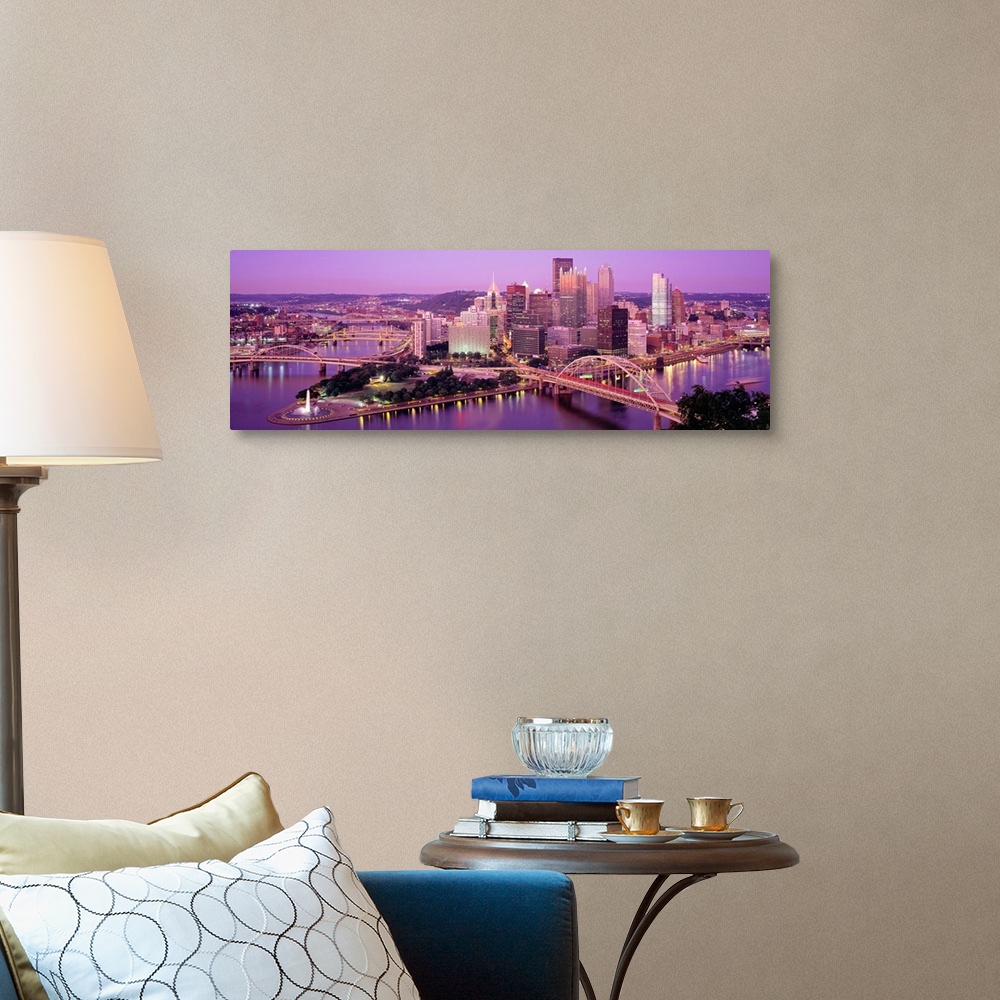 A traditional room featuring Panoramic photograph of downtown Pennsylvania as the sun sets.  There are building, bridges, a fo...