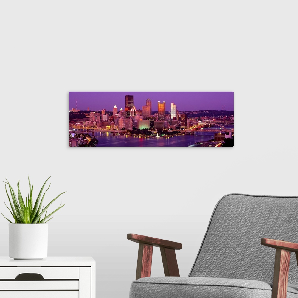 A modern room featuring Large print of a horizontal photograph of skyline in Pittsburgh, Pennsylvania at night.