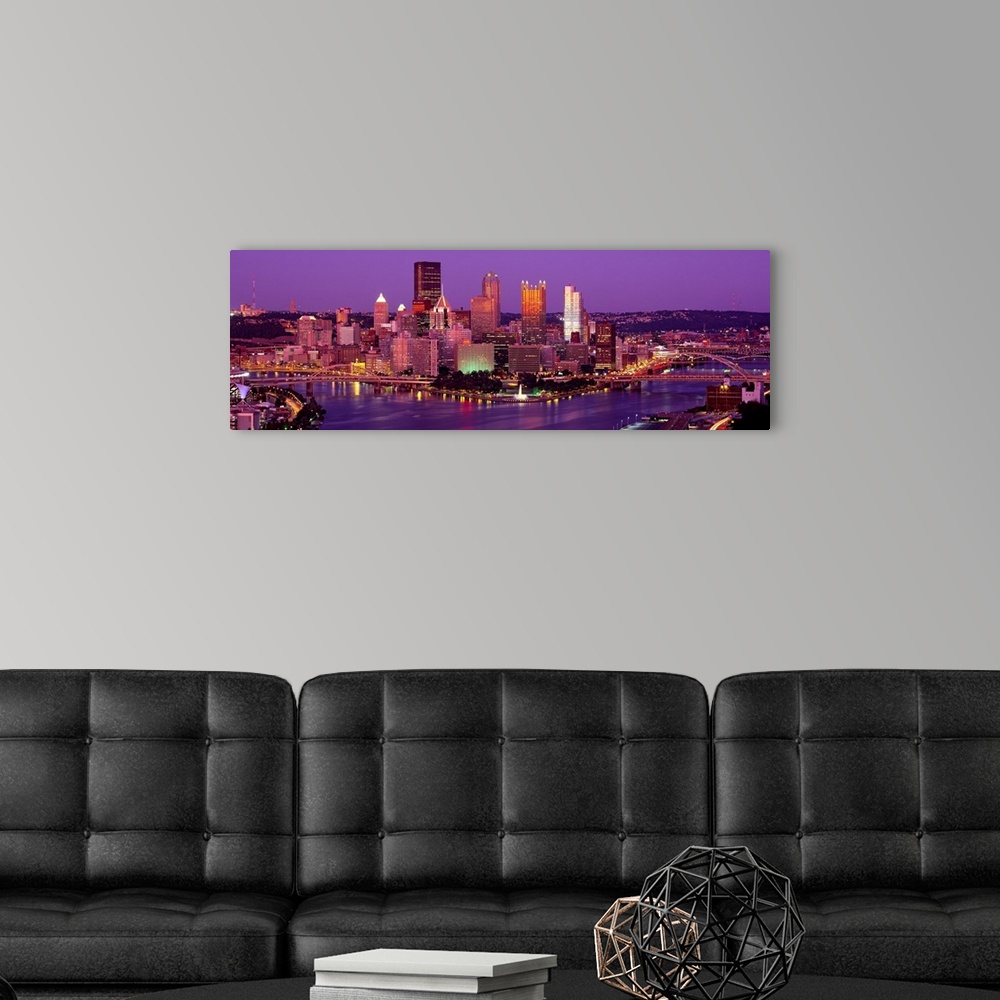 A modern room featuring Large print of a horizontal photograph of skyline in Pittsburgh, Pennsylvania at night.